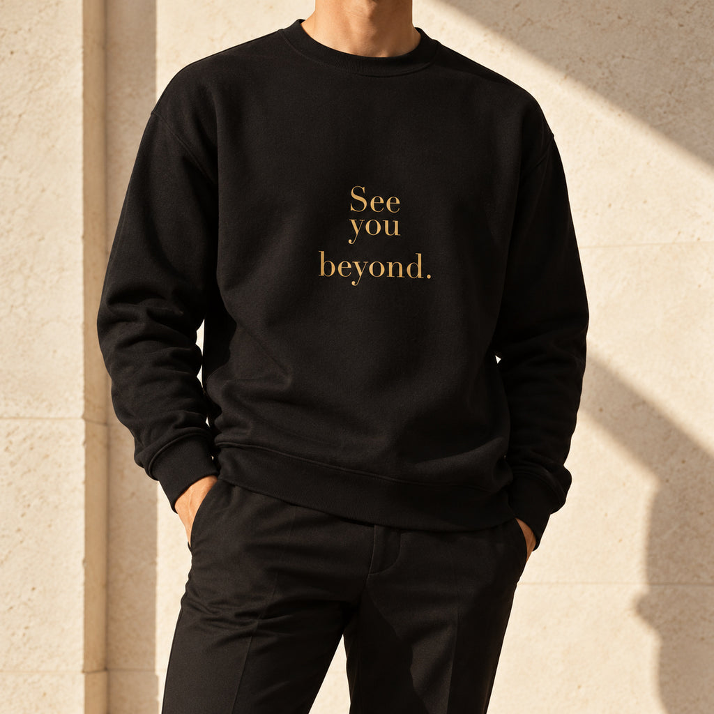 Beyond Crewneck in black, styled with tailored trousers; gold-tone See you beyond. print.