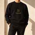 Beyond Crewneck in black, styled with tailored trousers; gold-tone See you beyond. print.