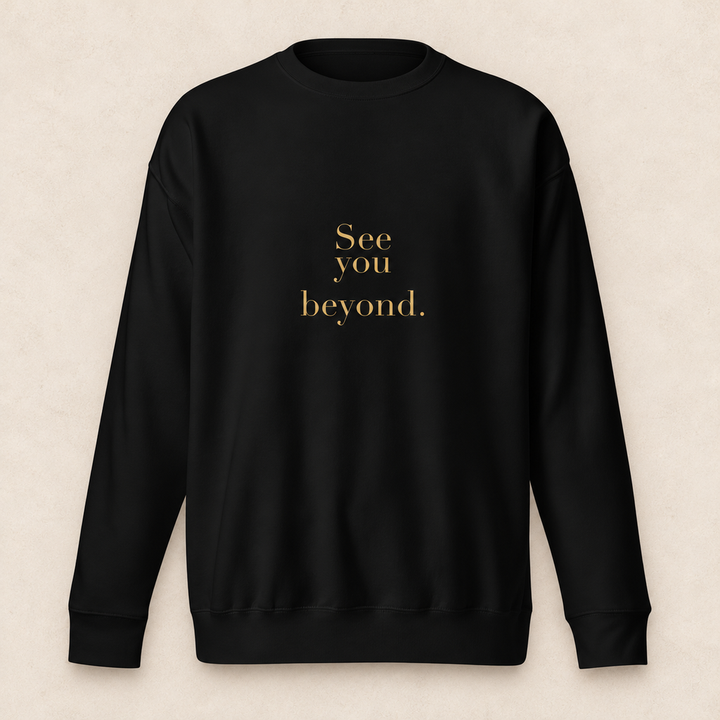beyond crewneck in black with original SYB gold artwork on a pale limestone studio background