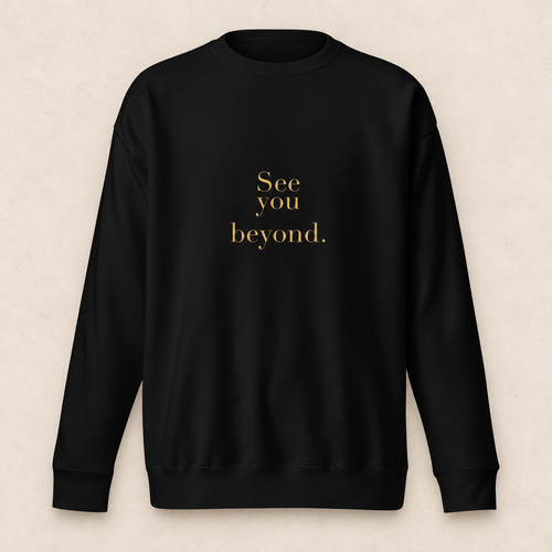 beyond crewneck in black with original SYB gold artwork on a pale limestone studio background