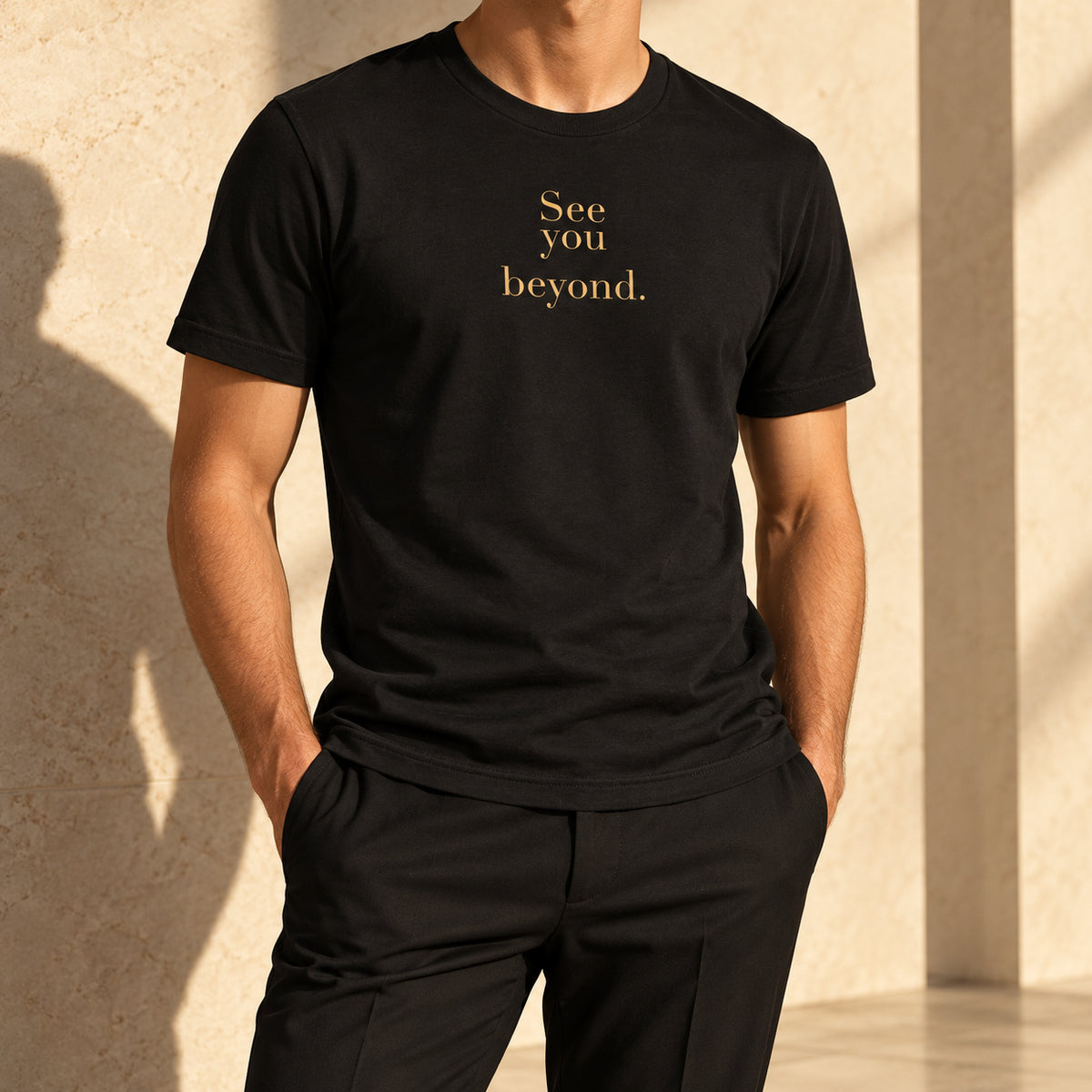 Beyond Tee in black, styled with tailored trousers; gold-tone See you beyond. front print.