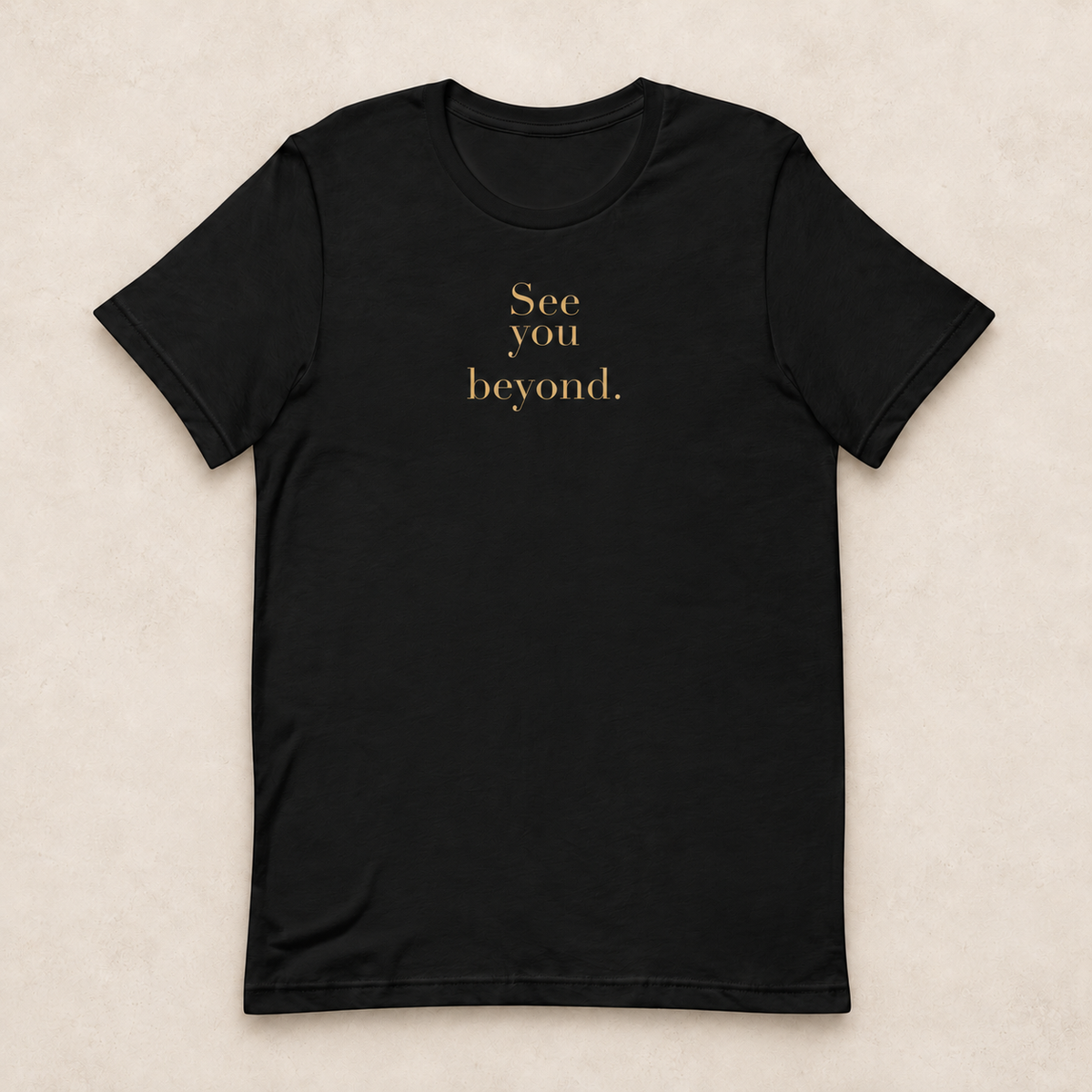 Beyond Tee in black with the gold-tone See you beyond. front print; studio mockup.