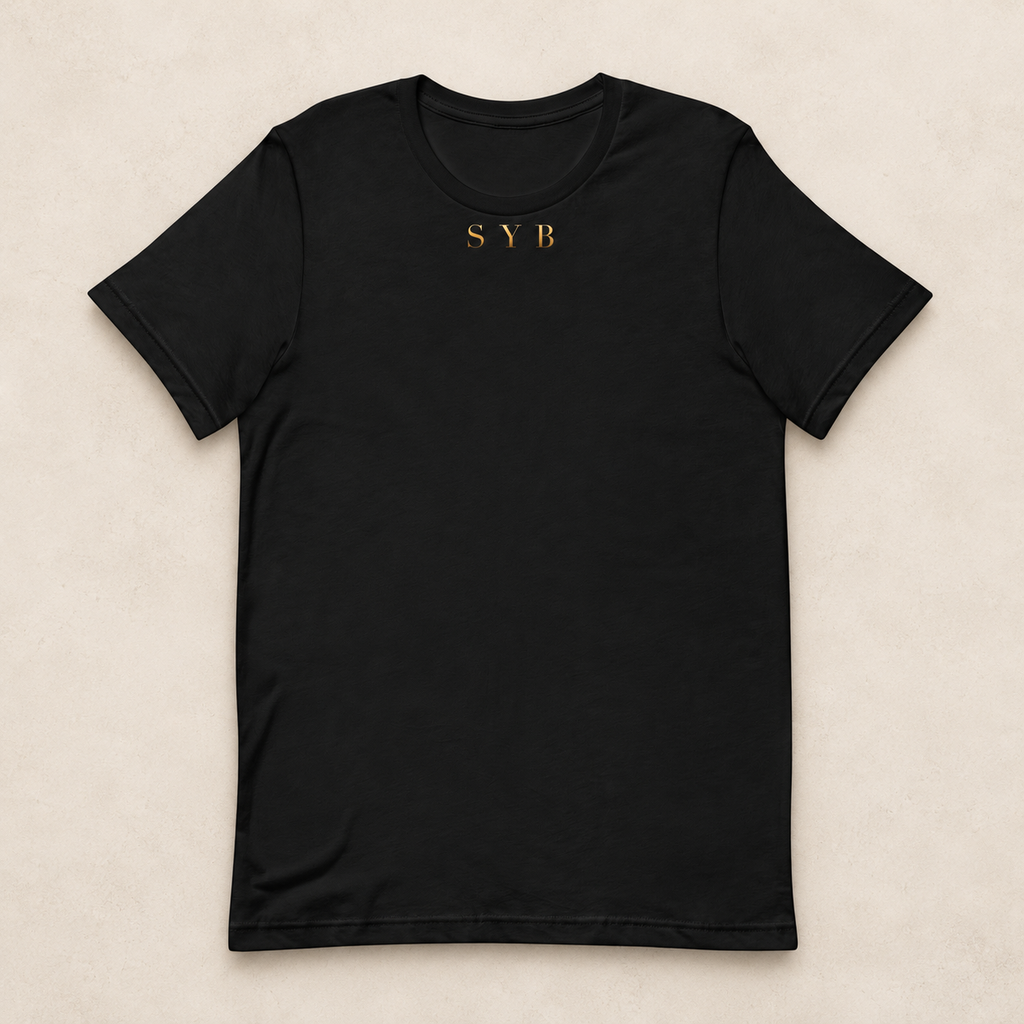 Wordmark Tee in black with a small gold-tone SYB front print; studio mockup.